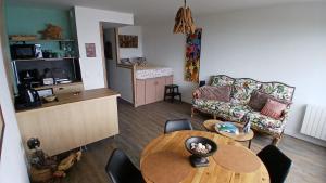 a living room with a table and a couch at Studio très belle vue mer in Pléneuf-Val-André
