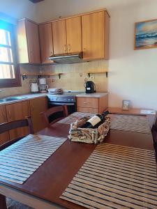 a kitchen with wooden cabinets and a wooden table with a table sidx sidx at Athina Studio Apartments in Kerveli +58 photos
