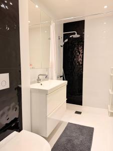 a white bathroom with a sink and a shower at Villa Daga in Vidsel
