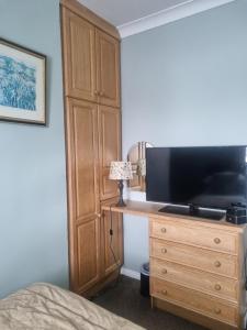 a bedroom with a television and a dresser with a bed at Glenduff Manor in Glendiff +16 photos