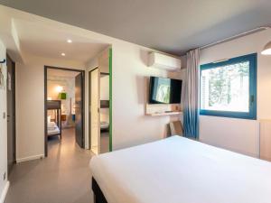 a bedroom with a white bed and a window at greet Hotel Bordeaux Aeroport in Mérignac +88 photos