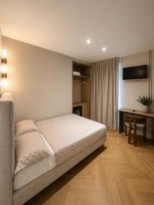 a bedroom with a bed and a table and a desk at Hôtel Belle Fontainebleau in Fontainebleau
