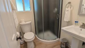a bathroom with a shower and a toilet and a sink at Rest Haven Motel in Los Angeles