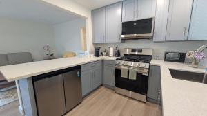 a kitchen with stainless steel appliances and white cabinets at Rest Haven Motel in Los Angeles
