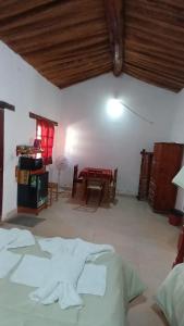 a room with a bed and a table and chairs at hospedaje chango luna in Purmamarca