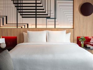 a bedroom with a white bed and a wall at Pullman Lima Miraflores in Lima