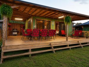 a wooden deck with red chairs on a house at JAWS Retreat Bungalow in Haleiwa +10 photos