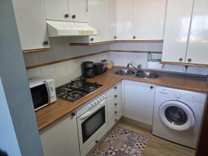 a kitchen with a stove top oven next to a sink at Atico in Noja Helgueras in Noja