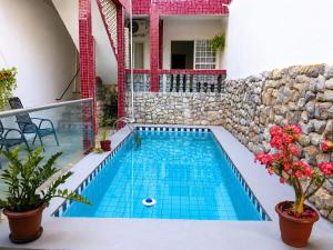 a swimming pool in a house with a stone wall at Hostel Goiabeiras com Piscina Próximo à Arena Pantanal in Cuiabá