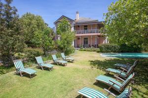 un grupo de sillas de jardín frente a una casa en Medindi Manor en Ciudad del Cabo