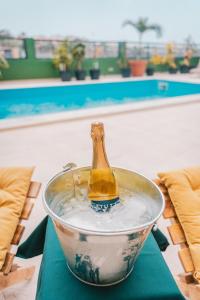 a bottle in a bucket of water on a table at Casa Jardim di Sol in Praia