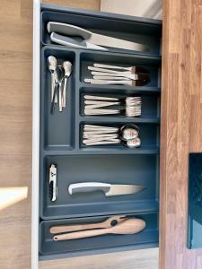 a drawer full of utensils in a cabinet at Le nid d'Eve - studio cosy près de Strasbourg avec piscine in Illkirch-Graffenstaden