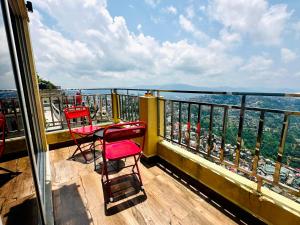 a balcony with two red chairs and a table on top at Aizawl Hotel in Āīzawl