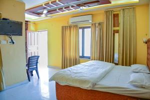 a bedroom with a bed and a table and a chair at Mahadev Mension Tapovan in Rishīkesh