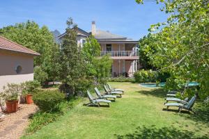 a row of chairs sitting in the yard of a house at Medindi Manor in Cape Town