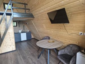 ein Zimmer mit Tisch und Stühlen und einer Treppe in der Unterkunft Haiduk Aframe in Brebu
