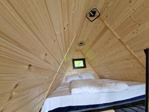 ein Bett in einem Holzzimmer in einem Zelt in der Unterkunft Haiduk Aframe in Brebu