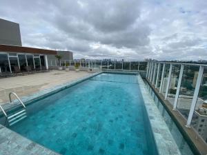 a swimming pool on the roof of a building at 1412 - Studio completo com varanda e vaga in São Paulo