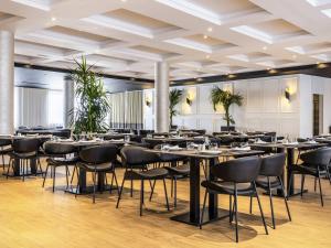 Mövenpick Hotel Lalez Durres في دراس: مطعم به طاولات وكراسي في غرفة