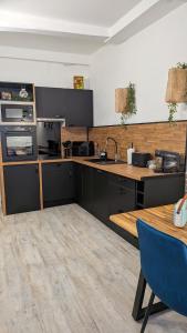 a kitchen with black cabinets and a wooden table at L'Atelier du Quai in Mâcon +23 photos