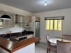 a kitchen with a sink and a table in a room at Sitio em São Pedro de Alcantara in São Pedro de Alcântara