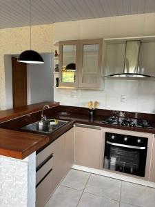 a kitchen with a sink and a stove at Sitio em São Pedro de Alcantara in São Pedro de Alcântara +7 photos