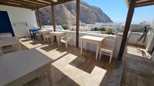 a restaurant with tables and chairs and a view of a mountain at Small Apartments Rooms Only in Perissa
