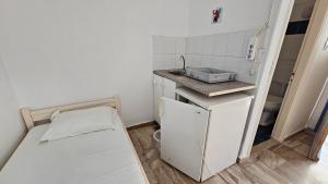 a small room with a bed and a sink at Small Apartments Rooms Only in Perissa