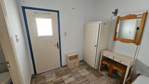 a bathroom with a door and a sink and a mirror at Small Apartments Rooms Only in Perissa