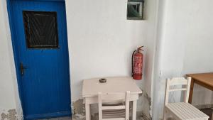 a room with a blue door and a table and chairs at Small Apartments Rooms Only in Perissa