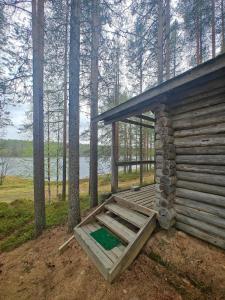 a log cabin with a porch in the woods at Hossa Teeriranta in Teeriranta