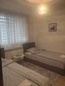 a small bedroom with two beds and a table at Hana in Konjic