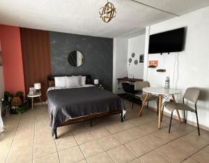 a bedroom with a bed and a table and a tv at Cond. St. Tropez in San Juan
