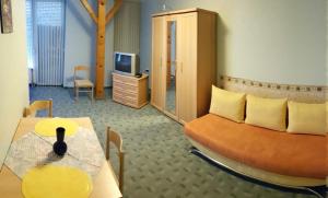 a bedroom with a bed and a table and a tv at Kastélykert Apartman in Gyula