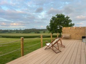 a wooden deck with a chair and a fence at Jimmy's Yurt in Shenley