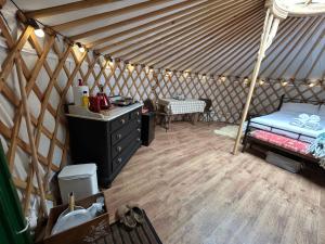 a room with a bed and a table in a yurt at Jimmy's Yurt in Shenley