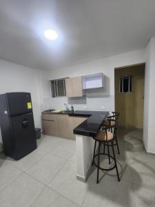 a kitchen with a black refrigerator and a table and chairs at apartaestudio 304 tranquilo, cómodo y moderno in Tuluá