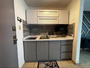 a small kitchen with a sink and a microwave at Cond. St. Tropez in San Juan