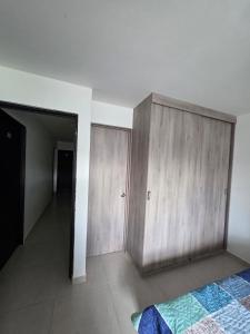 a bedroom with a wooden cabinet and a bed at apartaestudio 304 tranquilo, cómodo y moderno in Tuluá