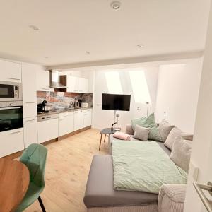 a living room with a couch and a kitchen at Ewelinas Altstudio in Sundern