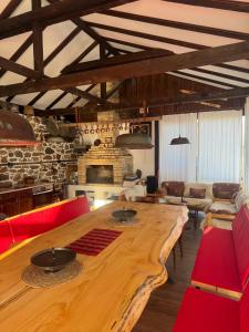 a large wooden table in a living room with red chairs at Villa Vera in Smilyan