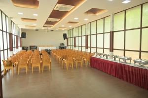 a large room with chairs and tables and windows at Winners Hill Resort Walayar by Arcadia in Coimbatore +82 photos