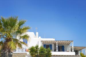 a white house with palm trees in front of it at Paraga Meltemi View in Platis Gialos