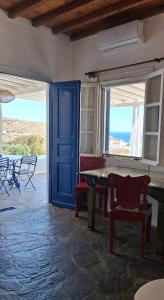 a room with a table and a blue door at Paraga Meltemi View in Platis Gialos