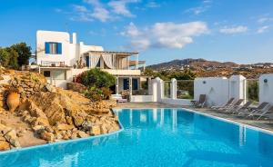 a villa with a swimming pool and a house at Paraga Meltemi View in Platis Gialos