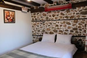 a bed in a room with a stone wall at Villa Vera in Smilyan