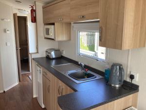 a kitchen with a sink and a counter top at Cosy Costal Escape in Westward Ho