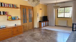 a living room with a wooden door and a tv at Casa El Jazmín in Alfacar