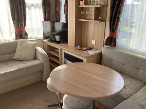 a living room with a table and a television at Cosy Costal Escape in Westward Ho
