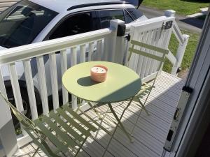 a green table and a chair on a porch at Cosy Costal Escape in Westward Ho